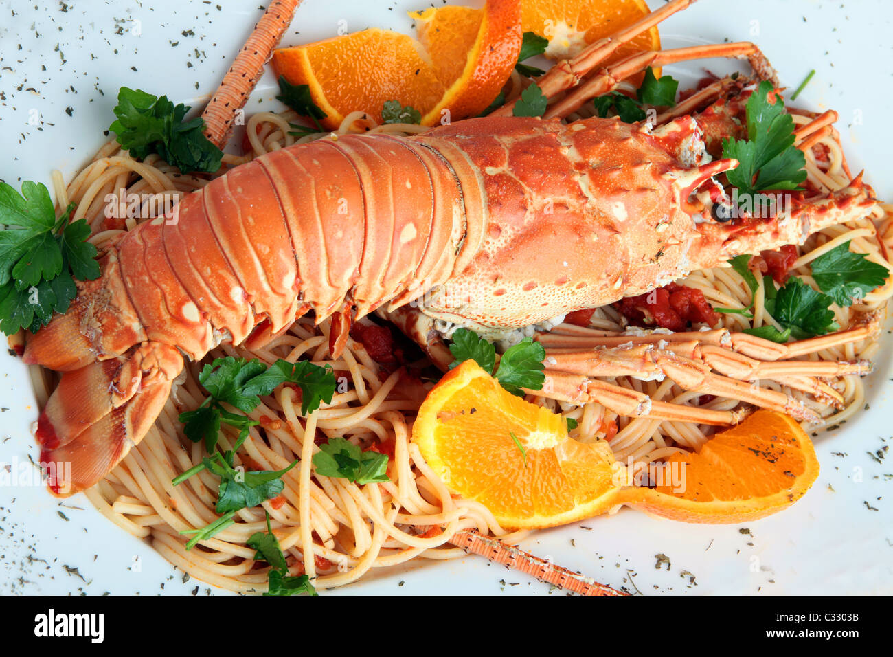 Homard cuit sur pâtes décorées avec des tranches d'orange et le persil, Grèce Banque D'Images