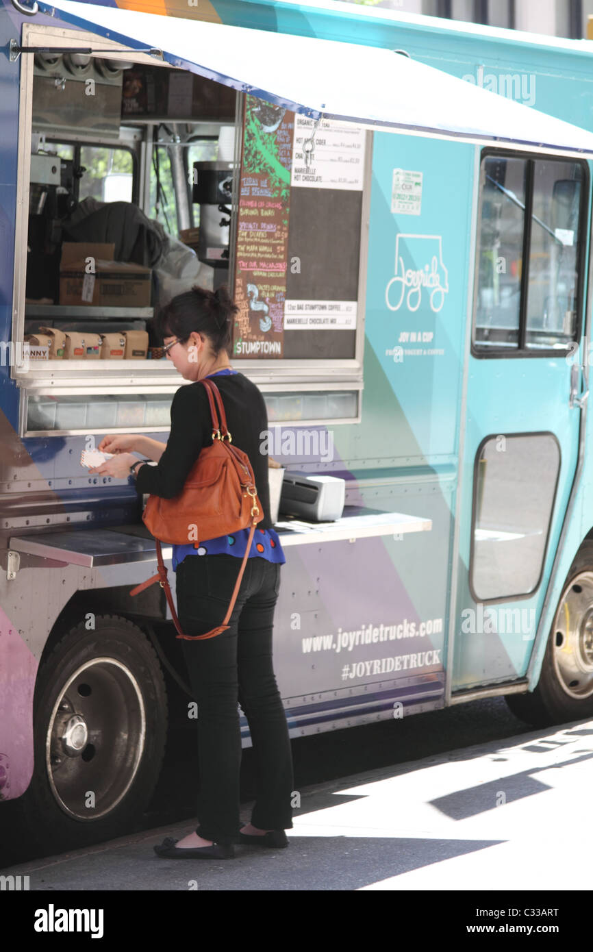 Femme de l'achat d'un fournisseur d'aliments de rue à New York City Banque D'Images