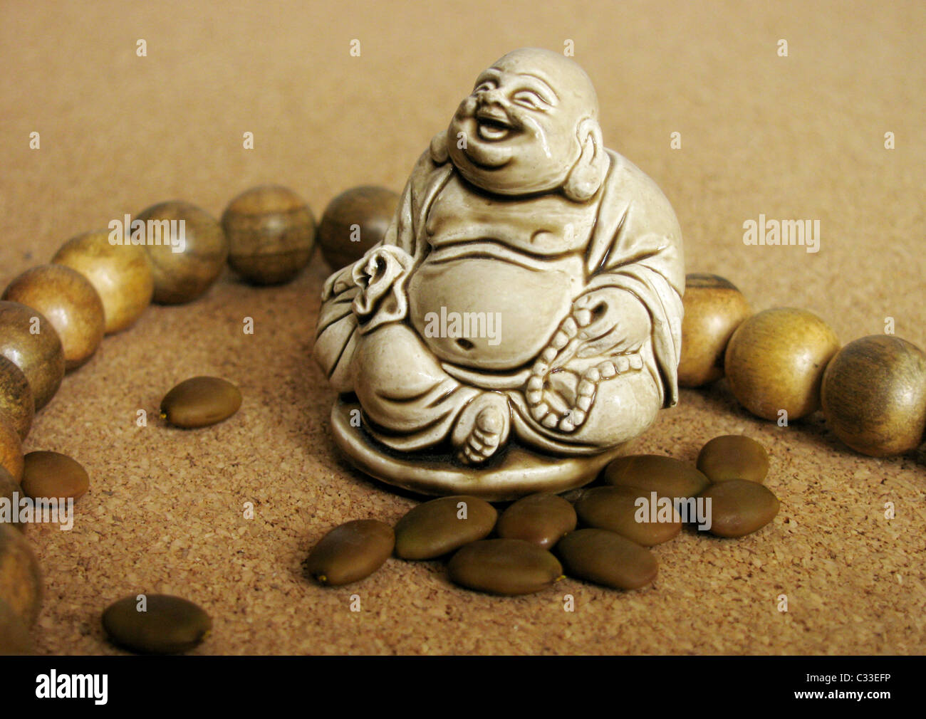 Statuette de Bouddha près d'une de perles et de graines Banque D'Images