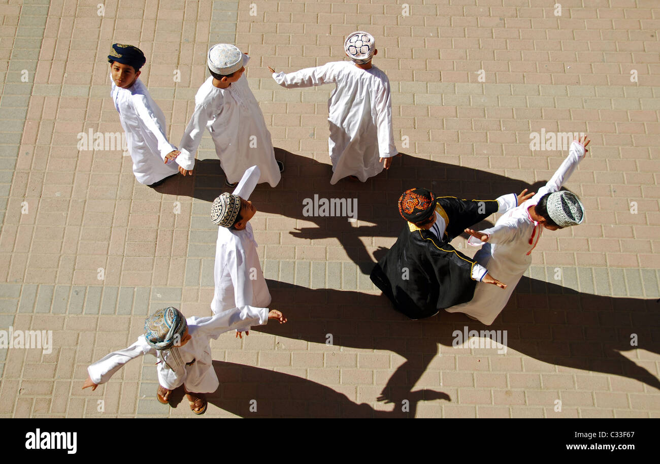 Oman, Muscat, vue du dessus de l'école des garçons debout avec les bras et la danse sur le terrain lors d'une journée ensoleillée Banque D'Images