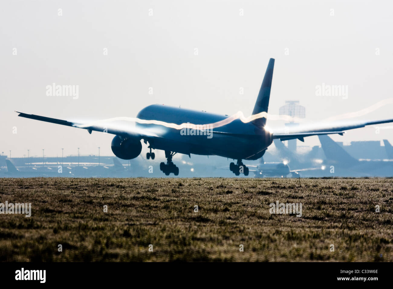 Avion de l'atterrissage à l'aéroport de Londres Heathrow avec les traînées de condensation formée au-dessus des ailes. Banque D'Images