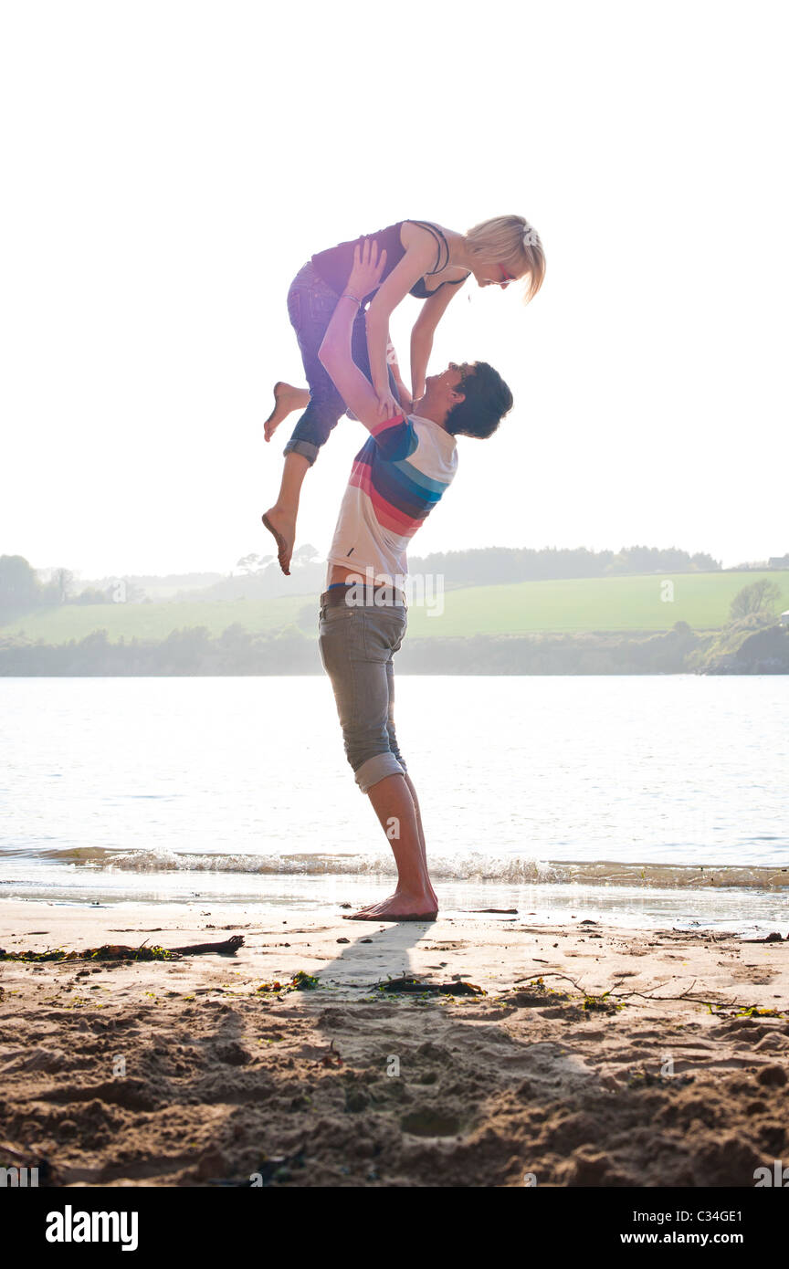 Man lifting girl sur la plage d'été, d'aimer Banque D'Images