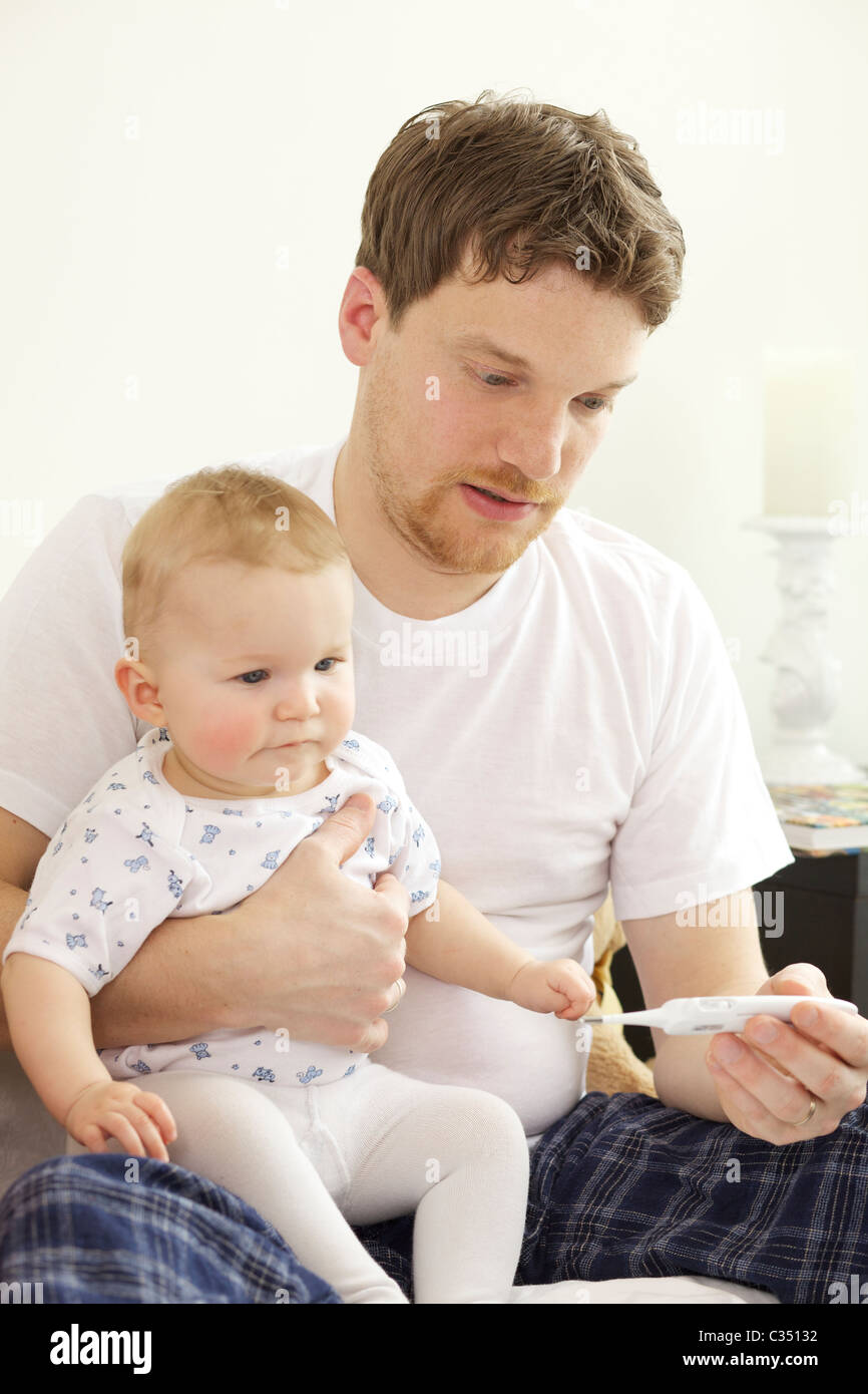 Vérification de son père avec la fièvre du bébé thermomètre numérique Banque D'Images