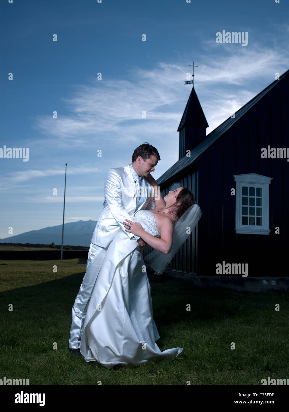 Mariée et le Marié danser devant Budir église avec Glacier Snaefellsjokull en arrière-plan, l'Islande Banque D'Images