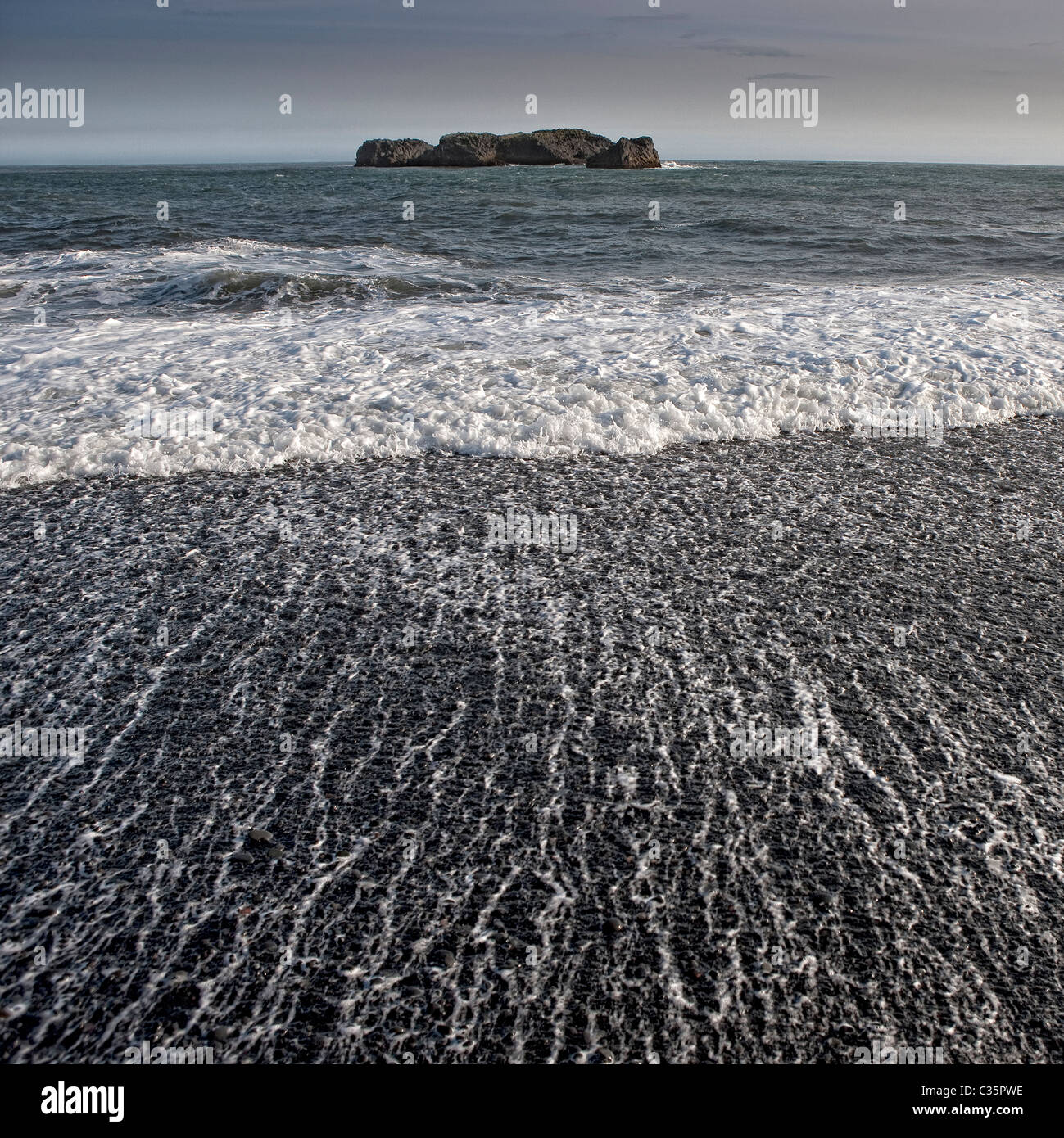 Plage de sable noir avec des vagues, Dyrholaey, Islande Banque D'Images