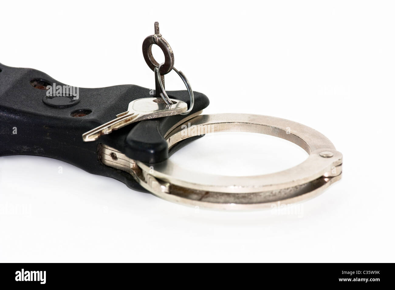 Close up of key in handcuffs isolated on white Banque D'Images
