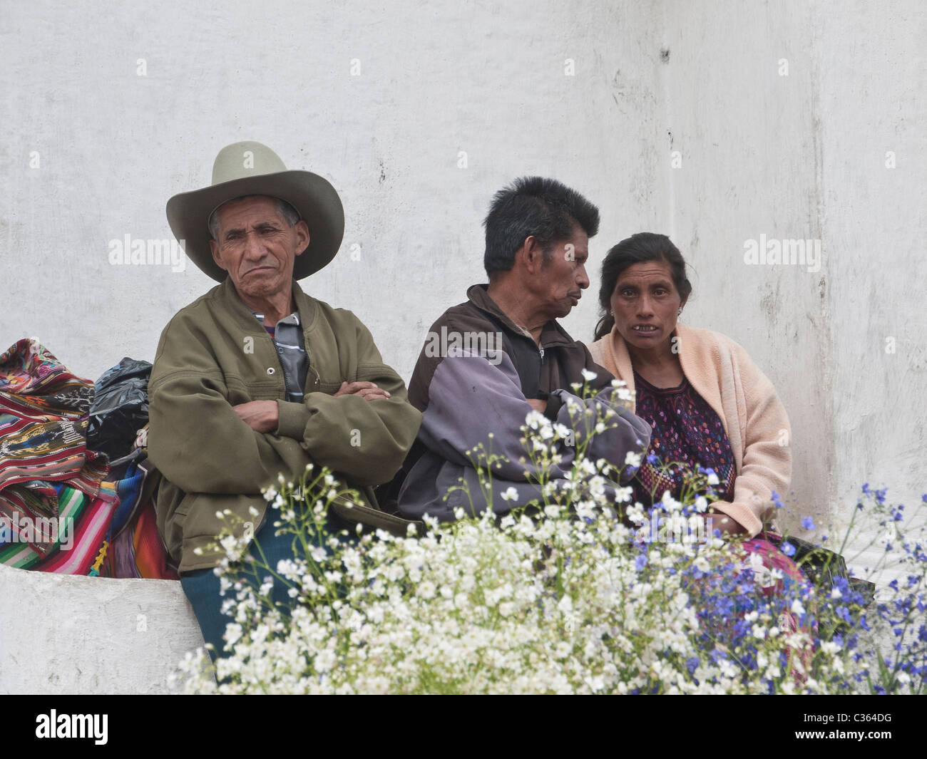Un groupe d'autochtones adultes assis au-dessus du marché aux fleurs sur les marches de la cathédrale principale à Chichicastenango, Guatemala Banque D'Images
