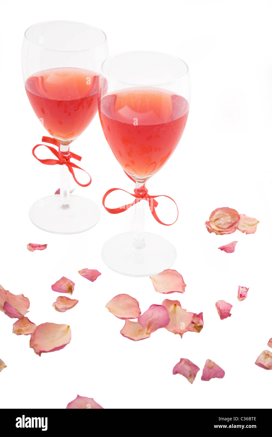 Deux vins rouges et des pétales de rose sur fond blanc Banque D'Images