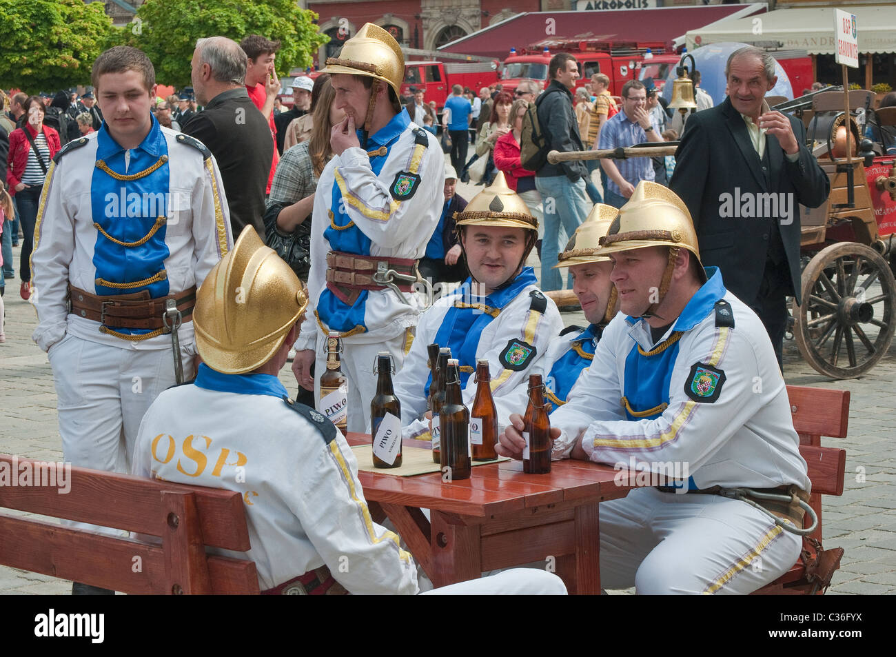 Village des bénévoles pompiers en uniformes historiques de boire de la bière au spectacle de rue sur les pompiers Journée à Rynek de Wrocław, Pologne Banque D'Images