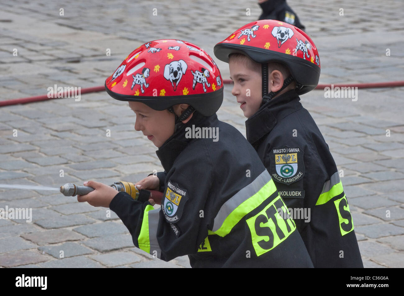 Les enfants à l'eau de pulvérisation, spectacle de rue (Bajkoludek Fablefolk) les enfants de pompiers, les pompiers jour festival, Wrocław, Pologne Banque D'Images