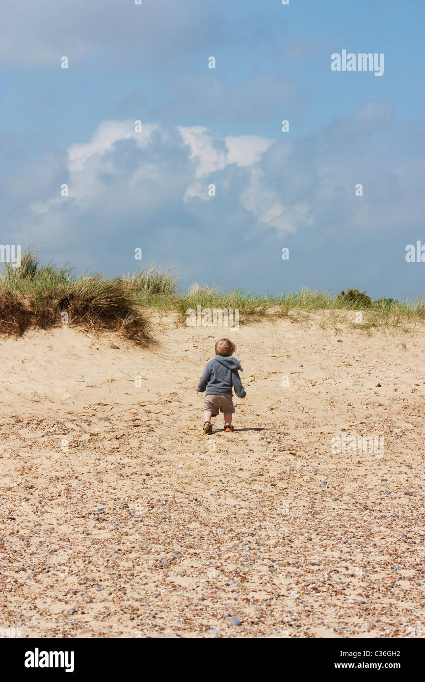 Un petit bébé garçon sur les dunes de sable de derrière Banque D'Images