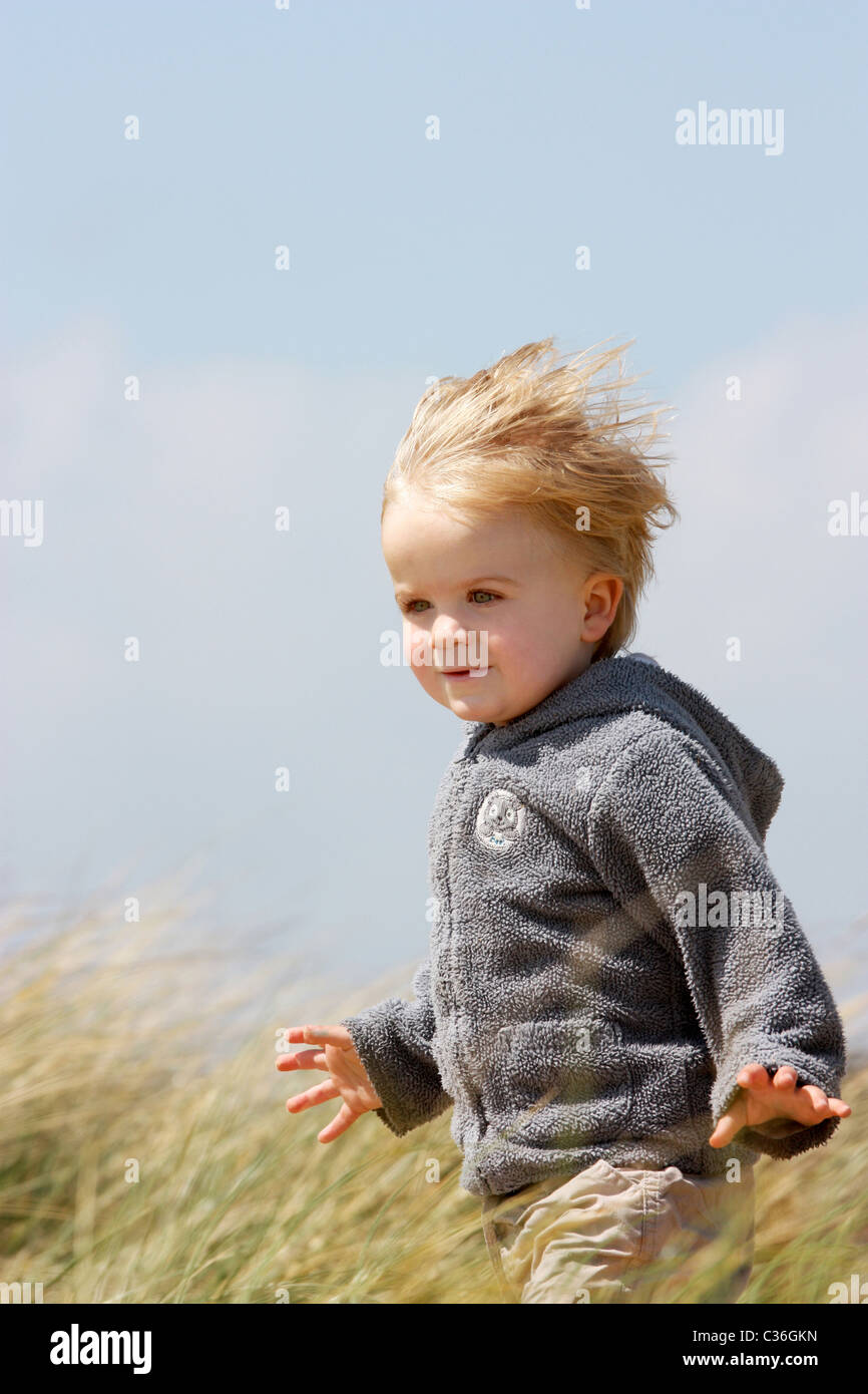 Little boy playing in sand dunes in uk Banque D'Images