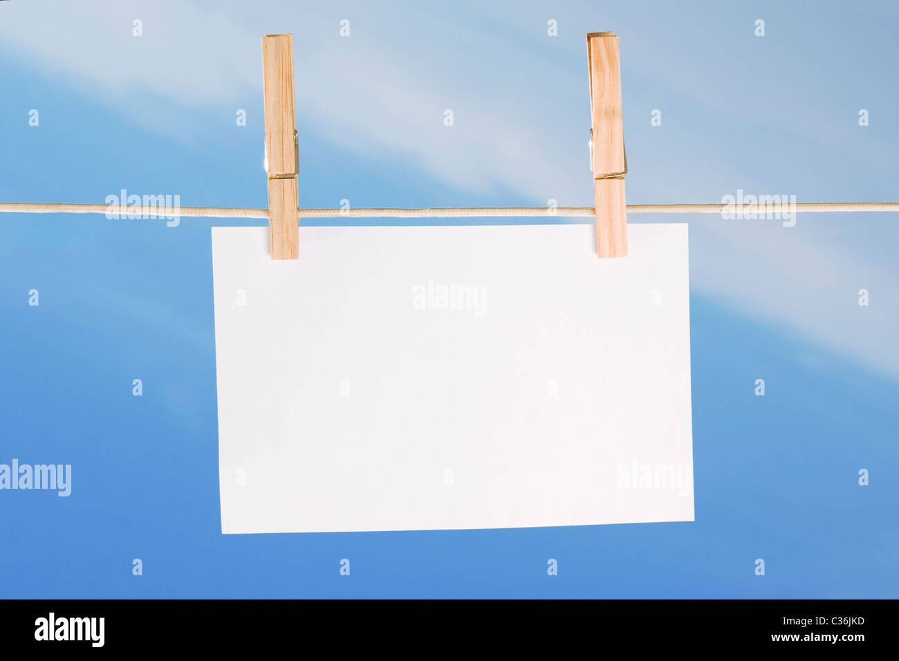 Le papier blanc et des vêtements peg sur fond de ciel bleu Banque D'Images