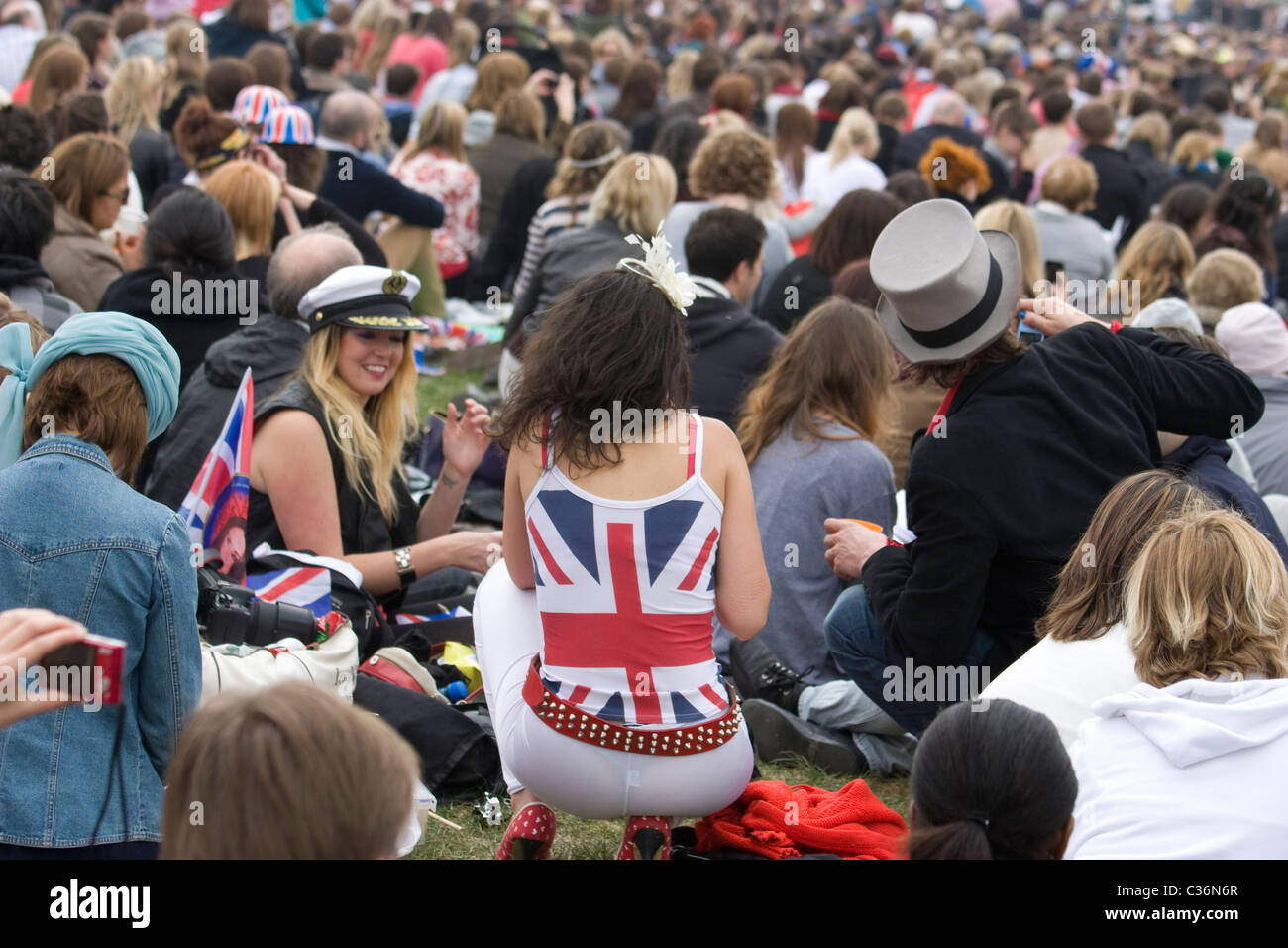 Les fêtards sont assis à Hyde Park devant des écrans géants diffusant le mariage royal du prince William, tout en portant les drapeaux de l'Union, Londres Royaume-Uni Banque D'Images