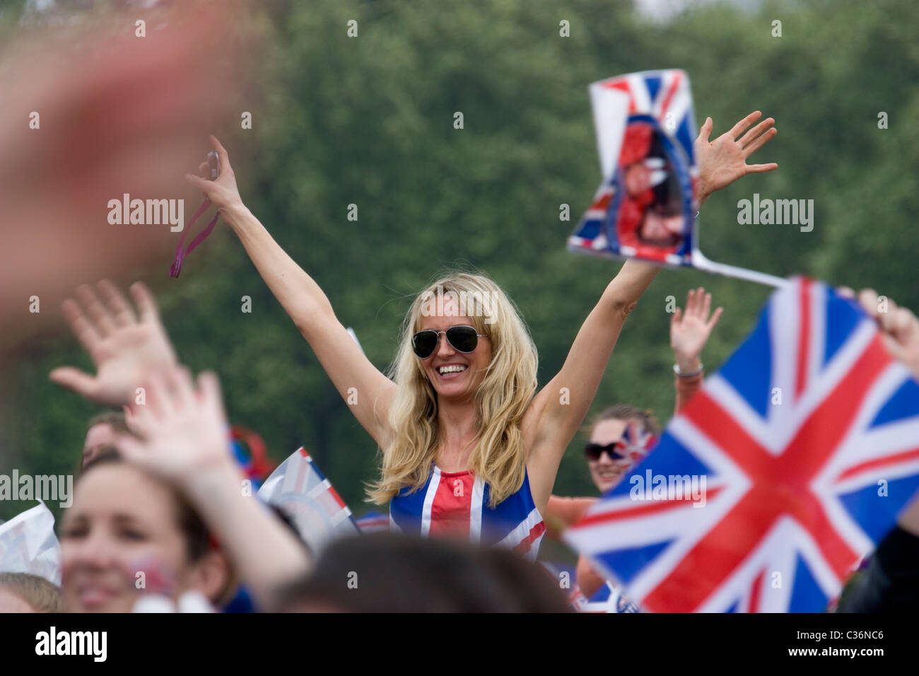 Fêteuse de mariage royale féminine avec robe union jack et drapeaux célèbre avec la foule à Hyde Park Londres, Royaume-Uni Banque D'Images