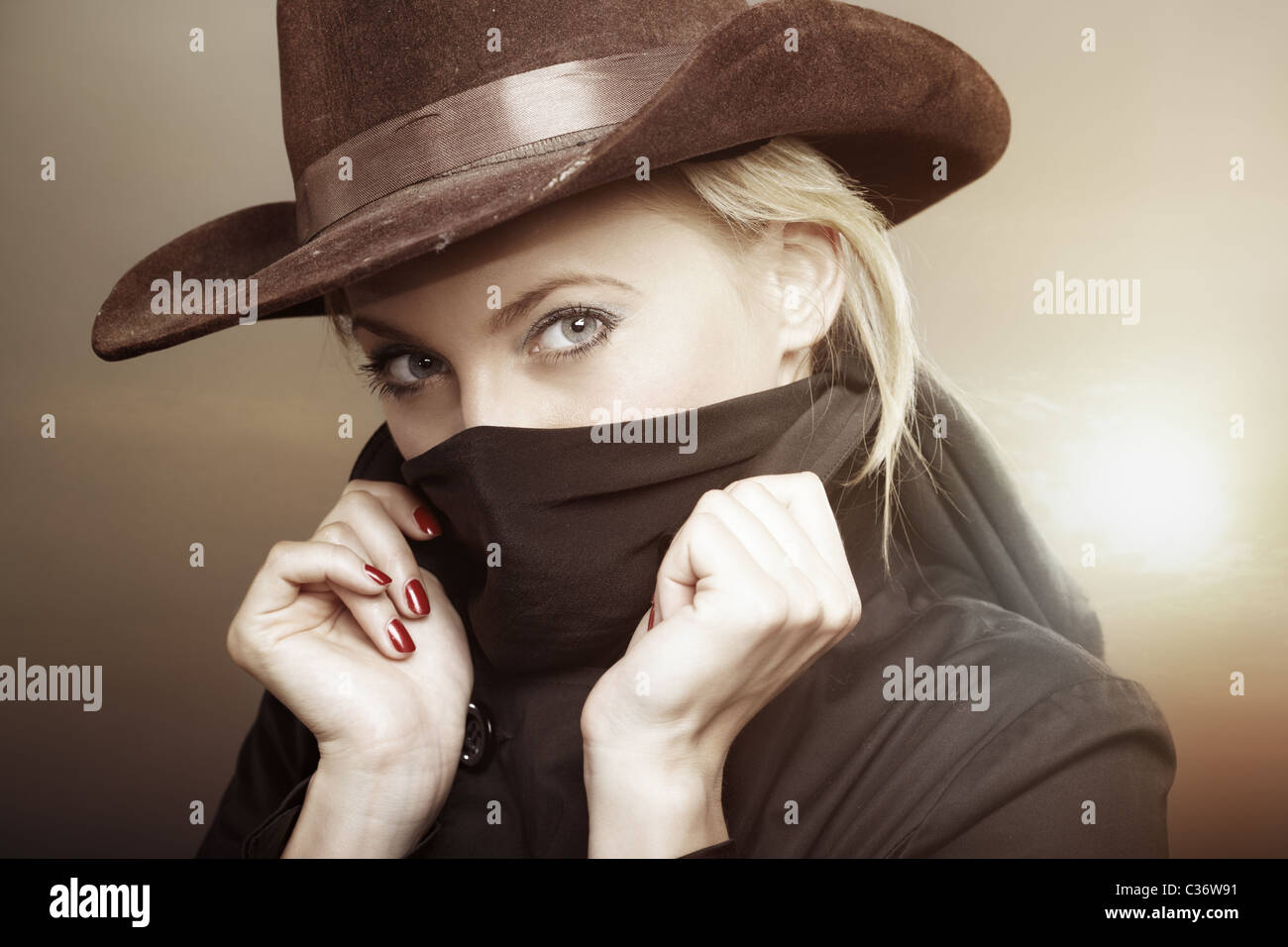 Femme criminelle avec chapeau de cowboy lors du coucher du soleil. Couleurs  créatives ajouté pour effet film Photo Stock - Alamy