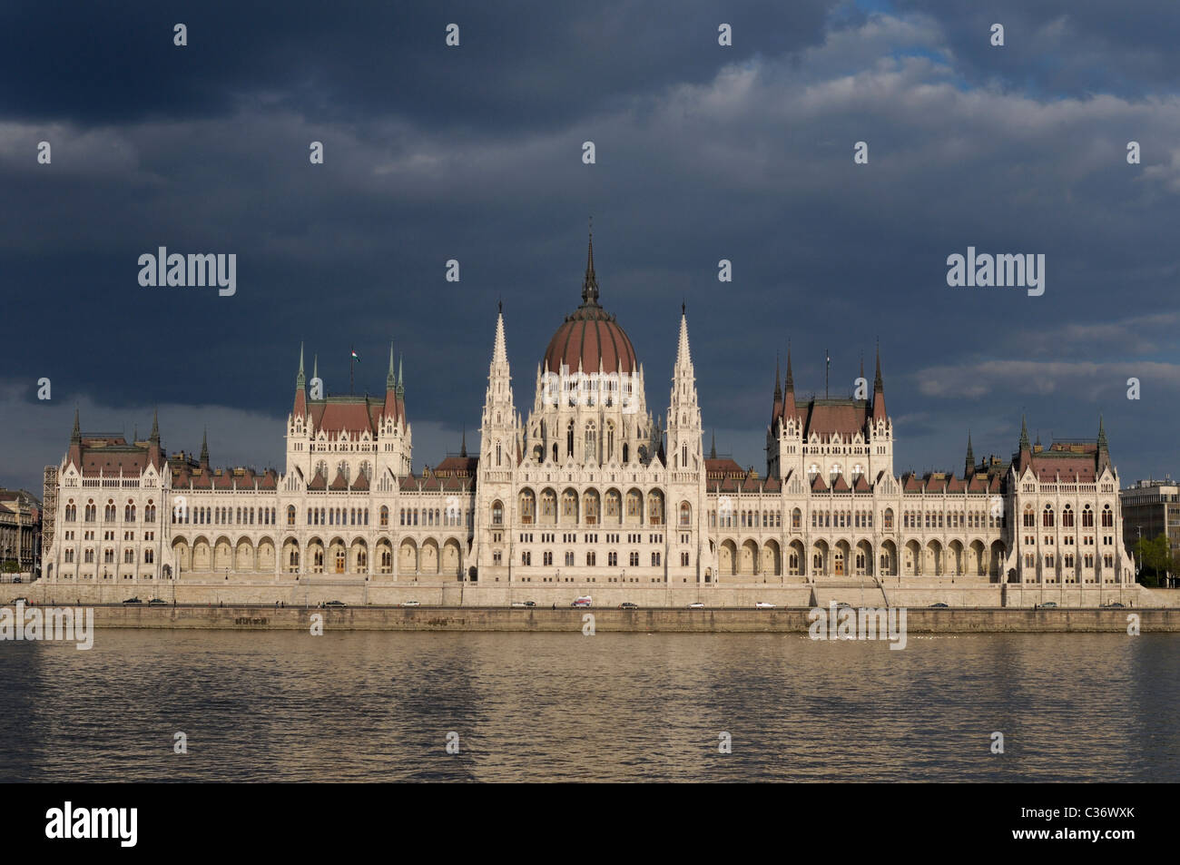 Bâtiment du Parlement hongrois avec des nuages sombres et du Danube. Banque D'Images