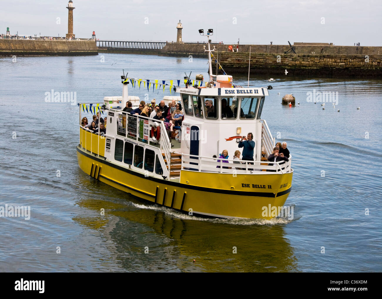 Bateau touristique jaune entrée en Whitby Harbour Harbour North Yorkshire angleterre Europe Banque D'Images