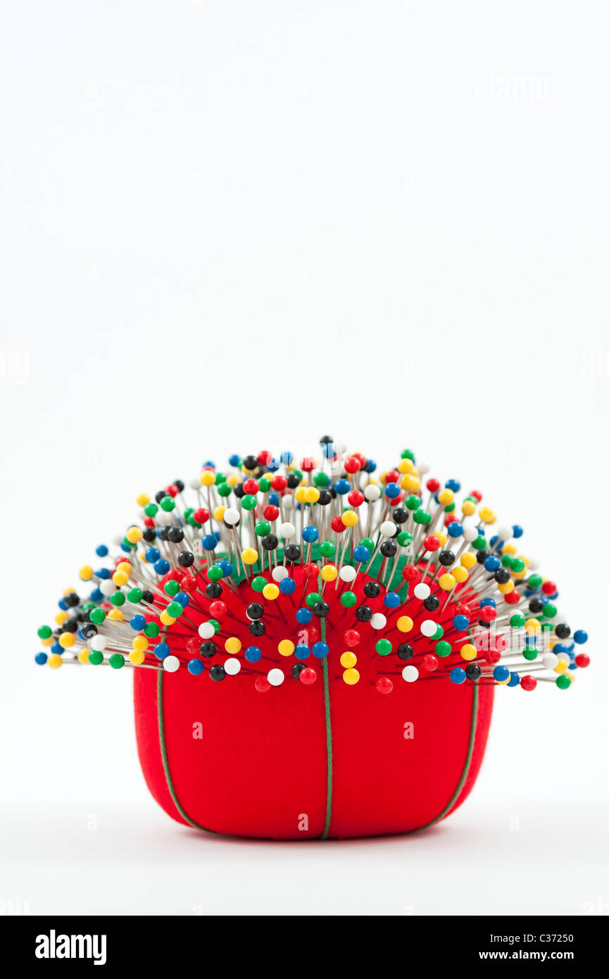 Broche rouge coussin avec broches de couleur multi coussin coincé dans  Photo Stock - Alamy