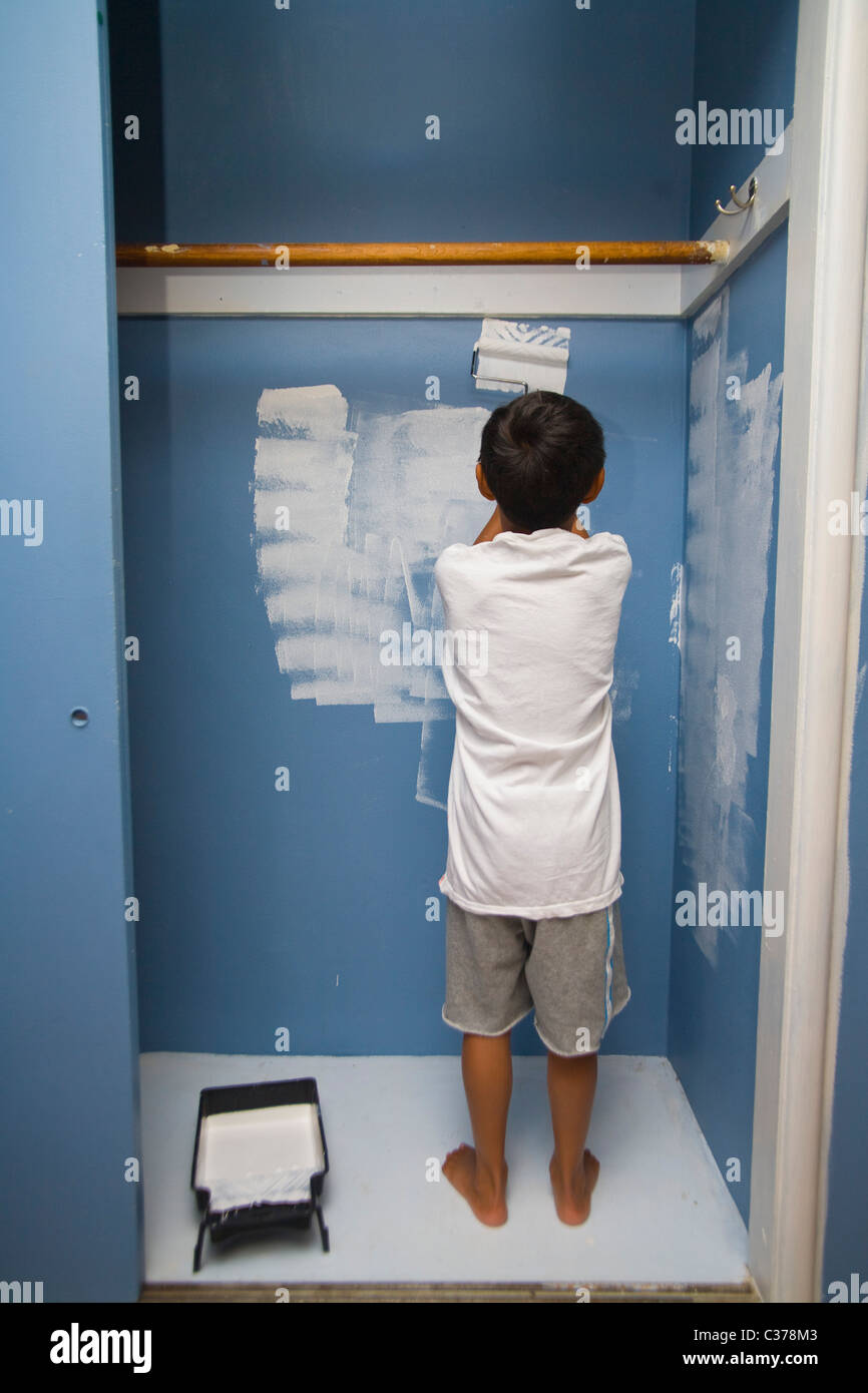 Boy painting wall en penderie Banque D'Images