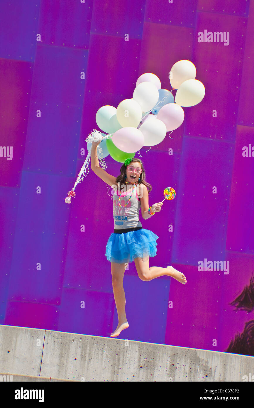 Teen girl holding bunch of balloons Banque D'Images