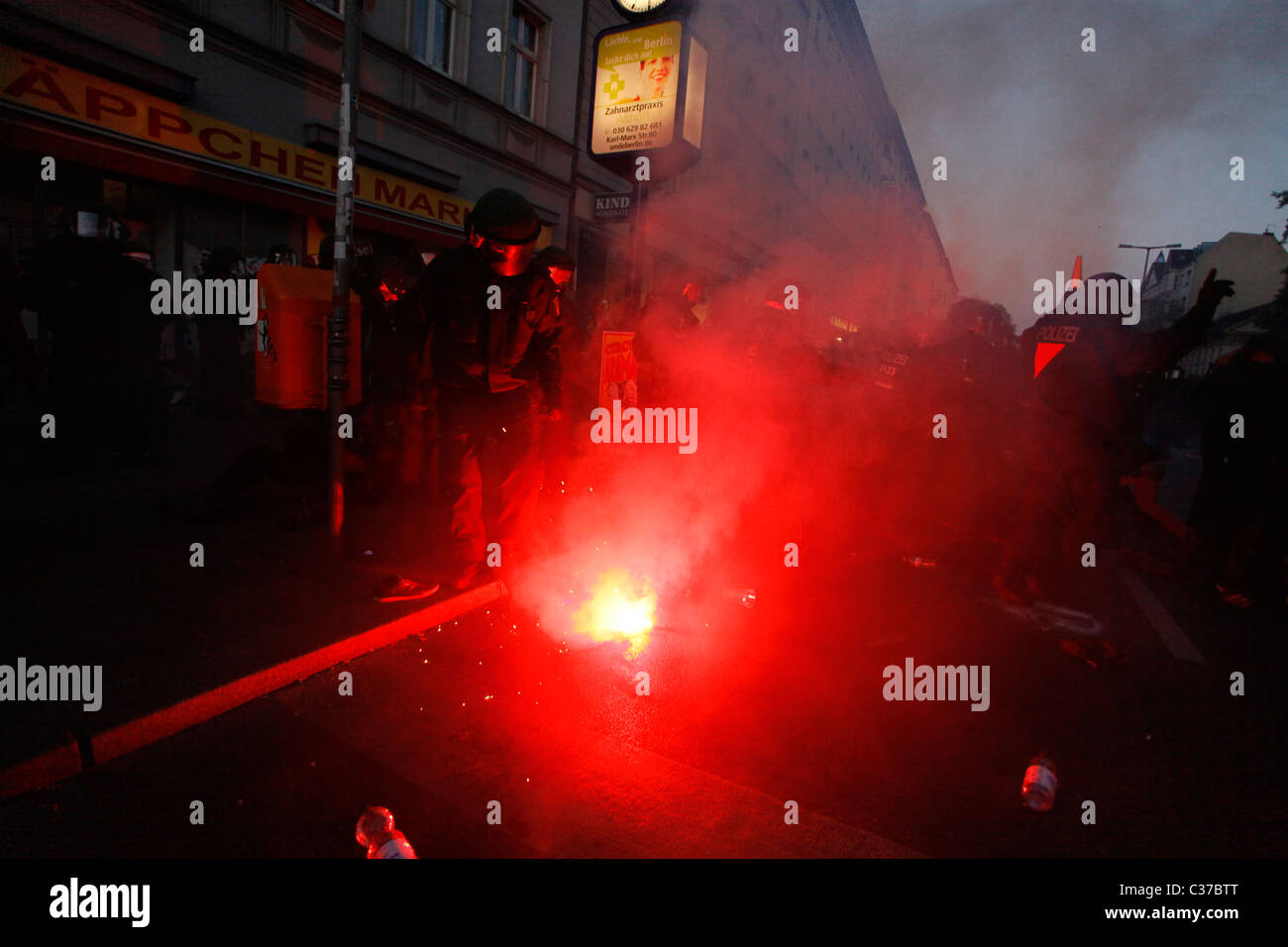 Des manifestants et des policiers se tiennent autour d'une éruption rouge, alors que de violents affrontements entre les militants de l'extrême gauche et la police d'Antifa ont eu lieu lors d'un rassemblement de protestation lors de la Journée internationale des travailleurs, également connue sous le nom de Fête du travail ou de mai, le 01 mai dans le quartier de Kreuzberg à Berlin en Allemagne Banque D'Images