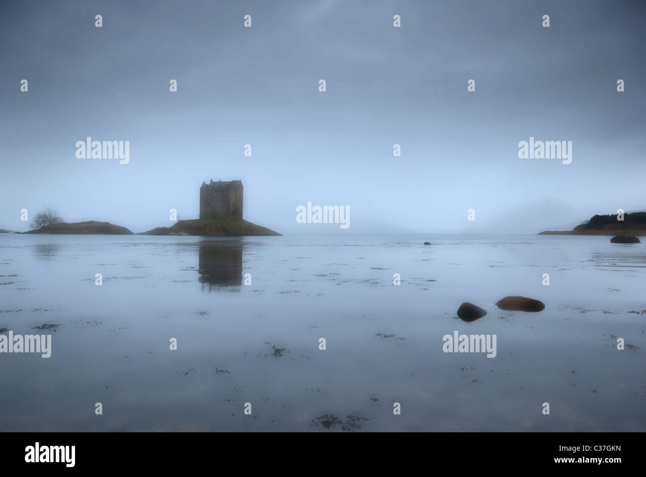 Vue impressionniste d'un château Misty dans un loch écossais Banque D'Images