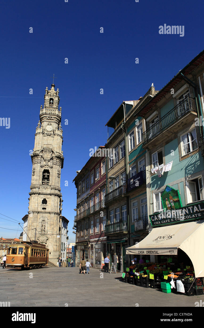 Un tram s'exécute par l'Église et la Tour des Clercs et la Casa boutique orientale à Porto, Portugal. Banque D'Images