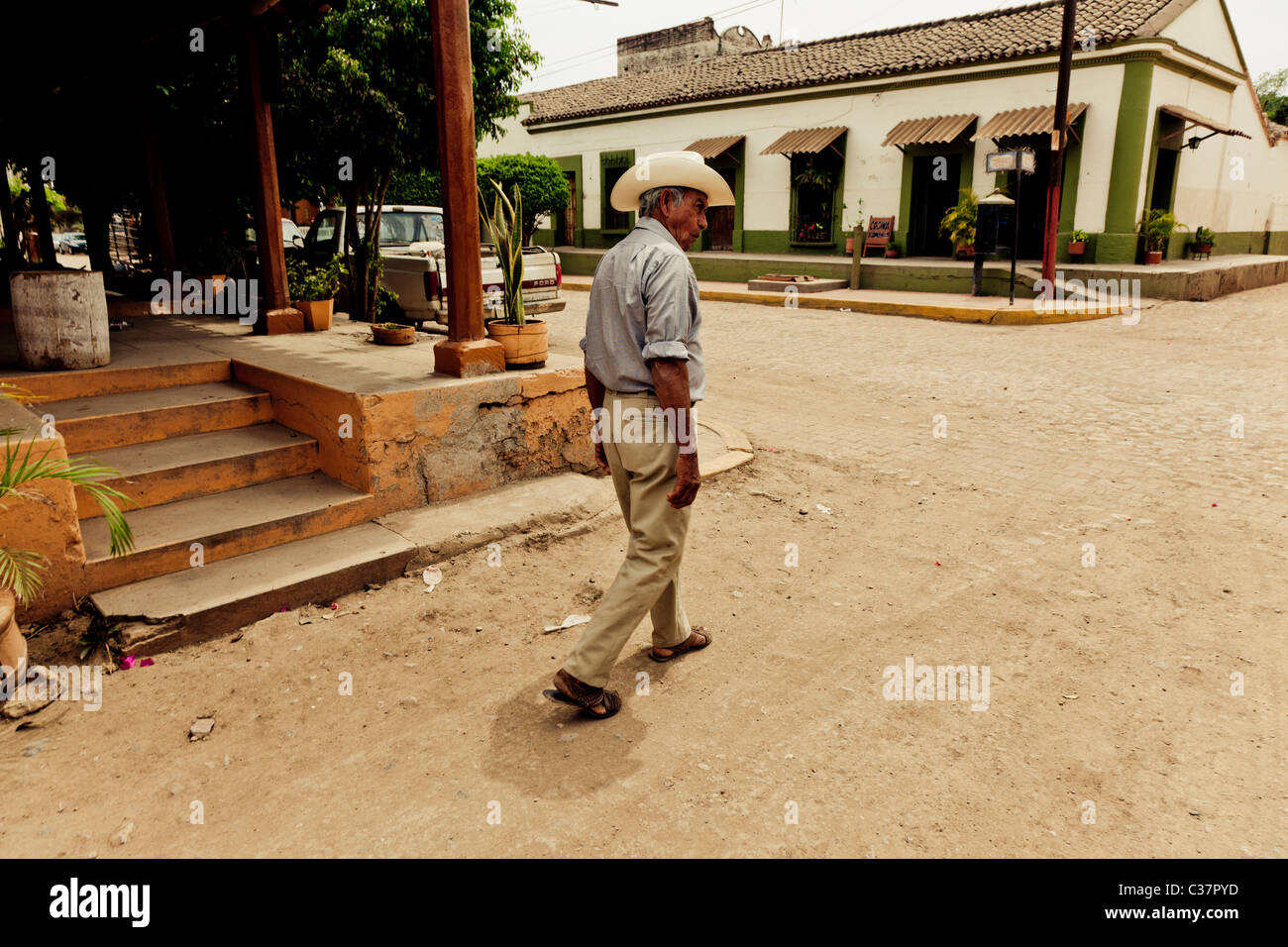 Un homme dans un chapeau blanc marche sur une rue poussiéreuse dans le village de Episode # 2.1 L'état de Sinaloa Mexique Banque D'Images