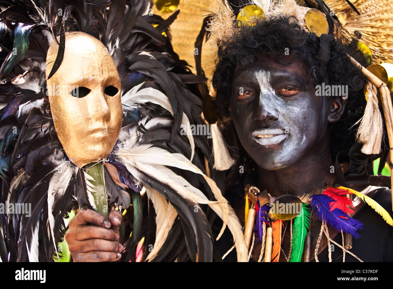 Un visage noir peint avec un danseur de rue masque supplémentaire. Banque D'Images