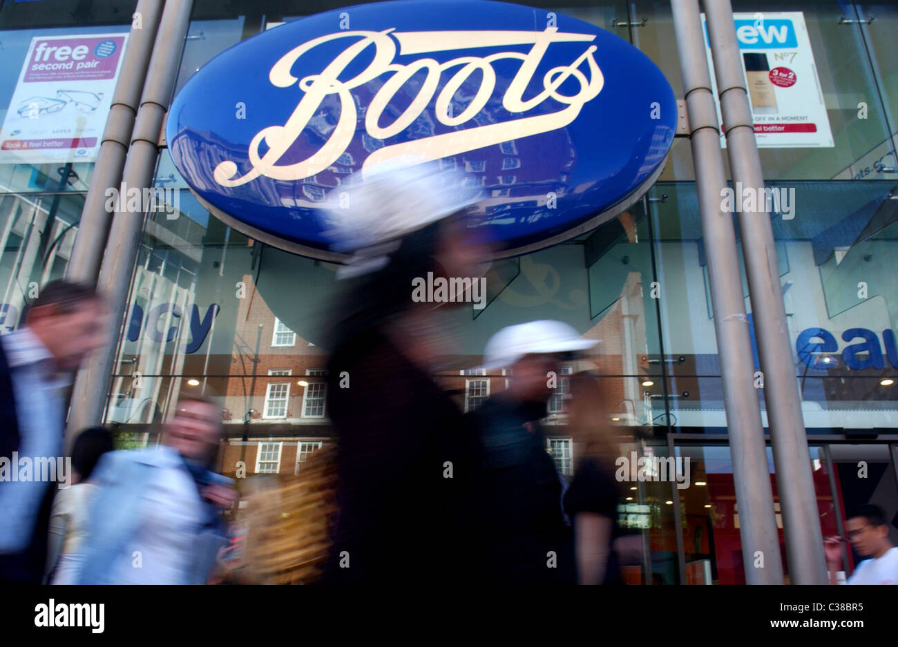 Les gens en passant devant un magasin de chaussures sur Oxford Street, Londres. Banque D'Images