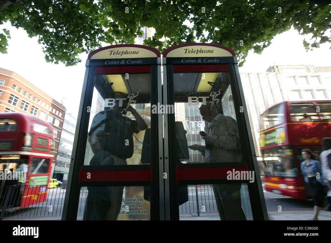 Deux hommes à l'aide de cabines téléphoniques BT dans le centre de Londres. Banque D'Images