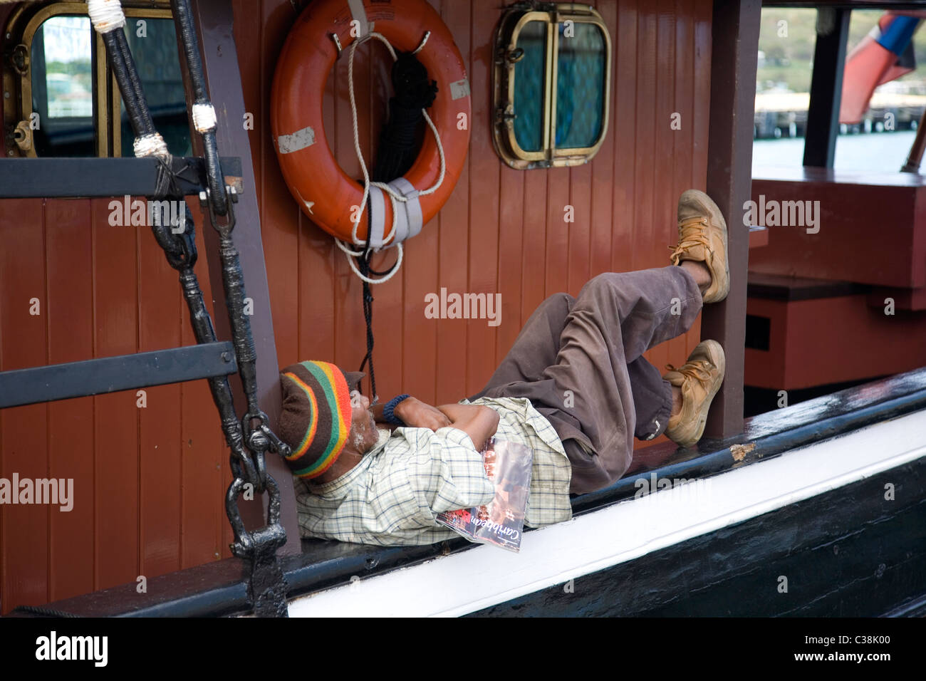 Rasta Man resting on boat à Redcliffe Quay à Antigua Banque D'Images