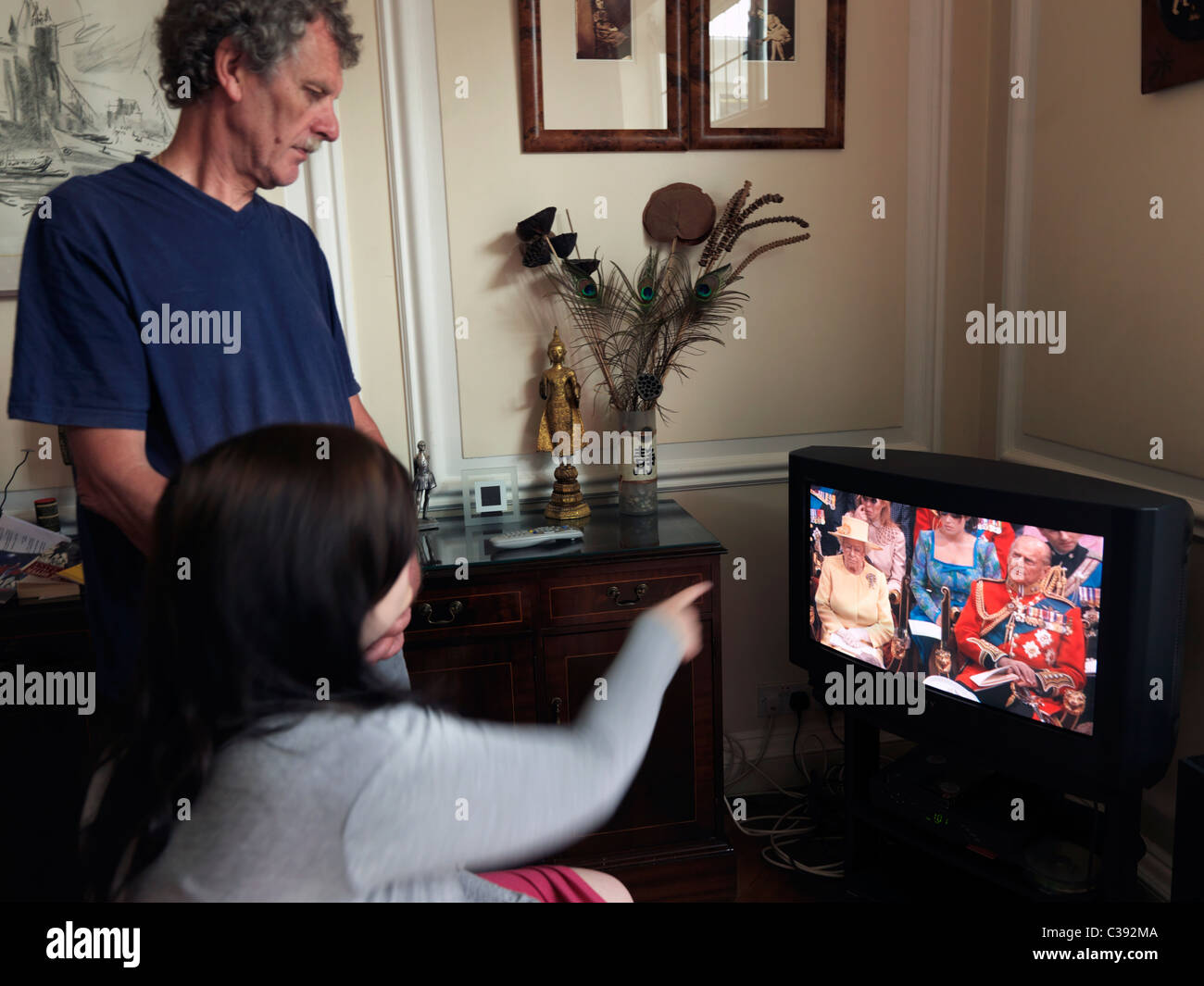 Père et fille adolescente regarder le mariage royal sur la télévision à la maison Banque D'Images