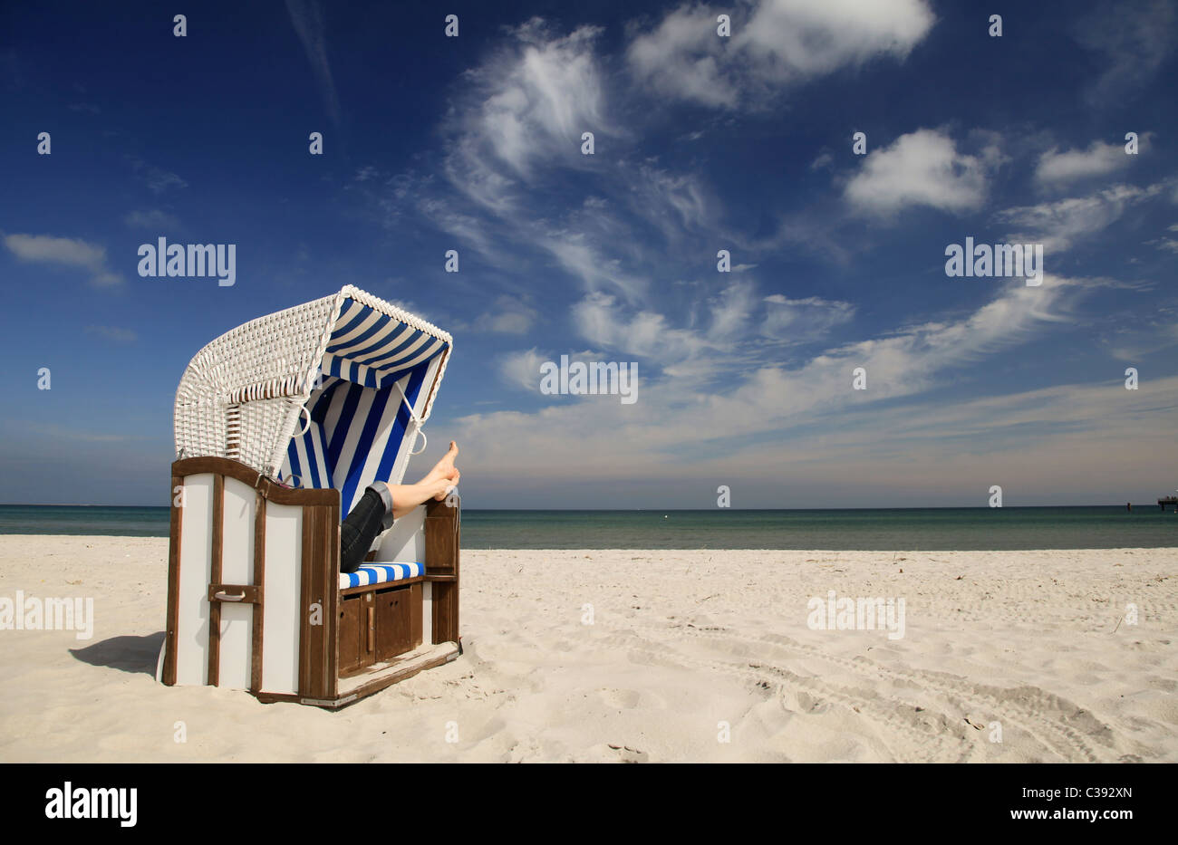 Chaise de plage avec une femme sur la plage Banque D'Images