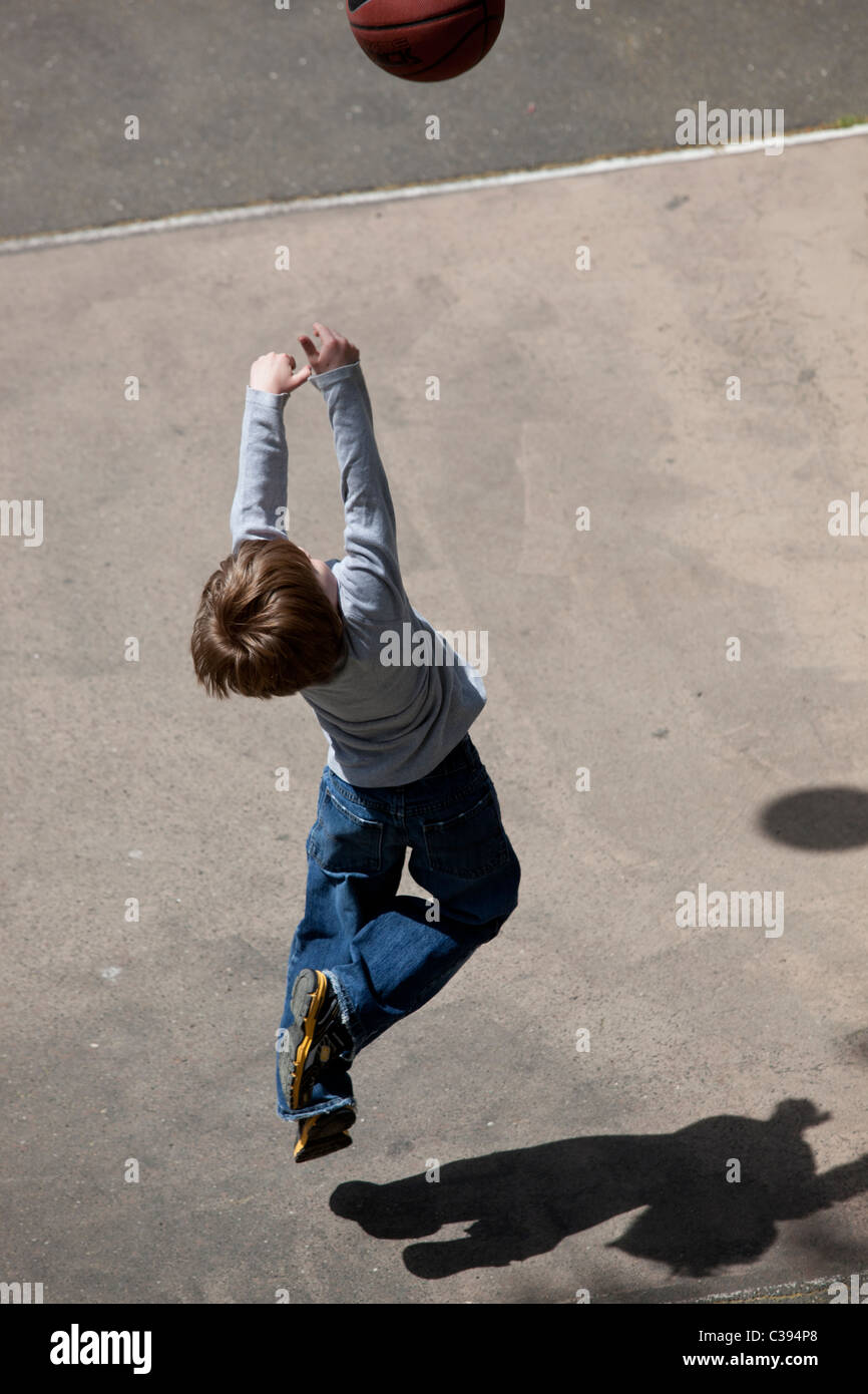 Jeune garçon jouant au basket-ball de rue à Riverside Park, New York City. Banque D'Images