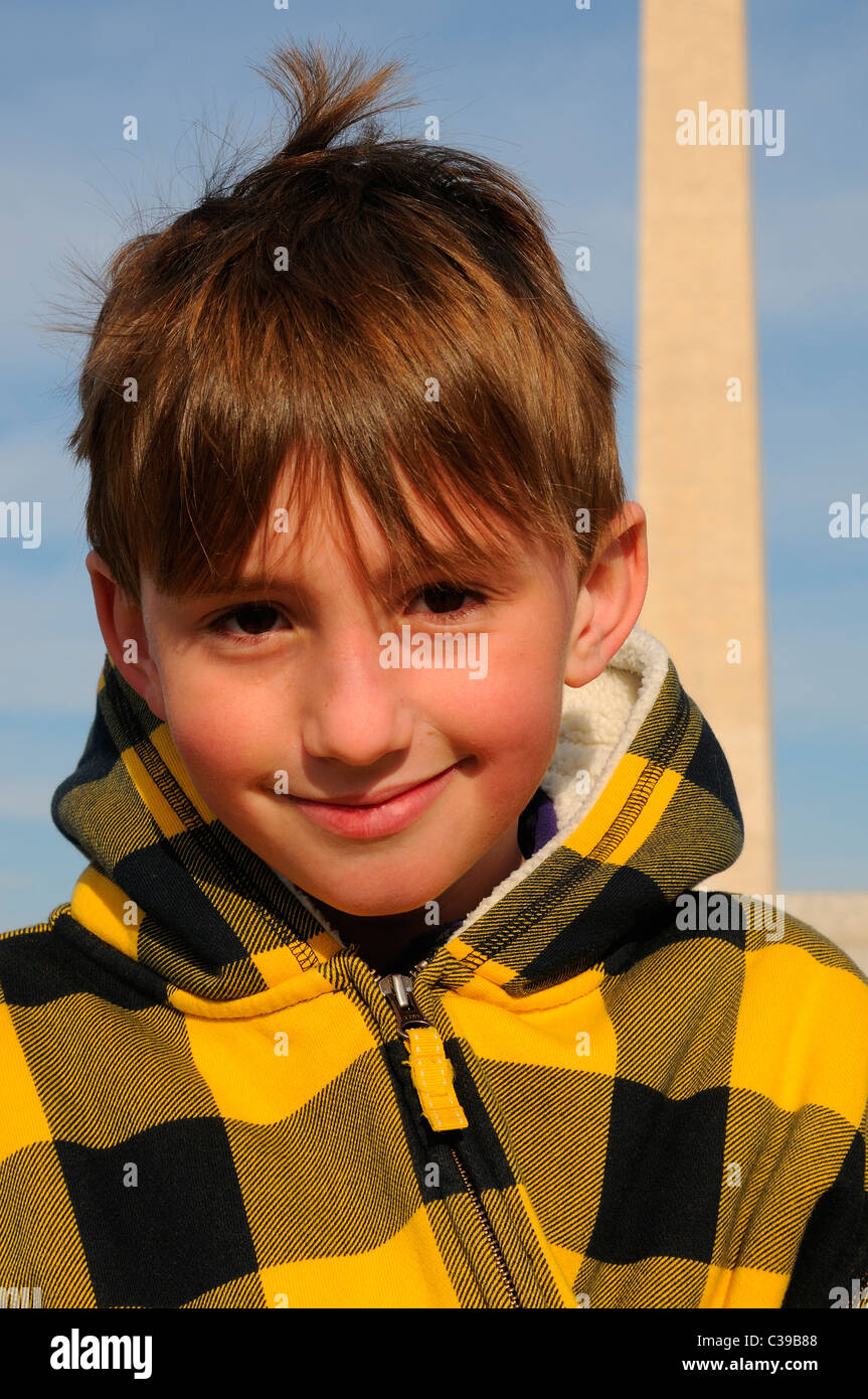 Photographie d'un jeune garçon avec le Washington Monument derrière lui. Banque D'Images