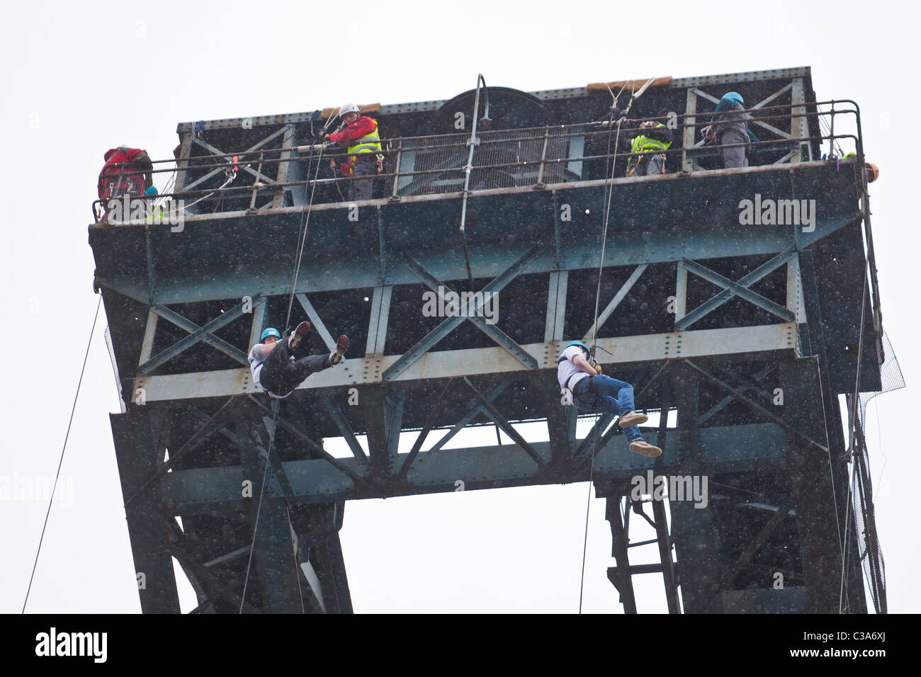 Deux personnes ont terminé un organisme de bienfaisance rappel sous la pluie, de la Glasgow Finnieston Crane, Stobcross. L'Écosse, au Royaume-Uni. Banque D'Images