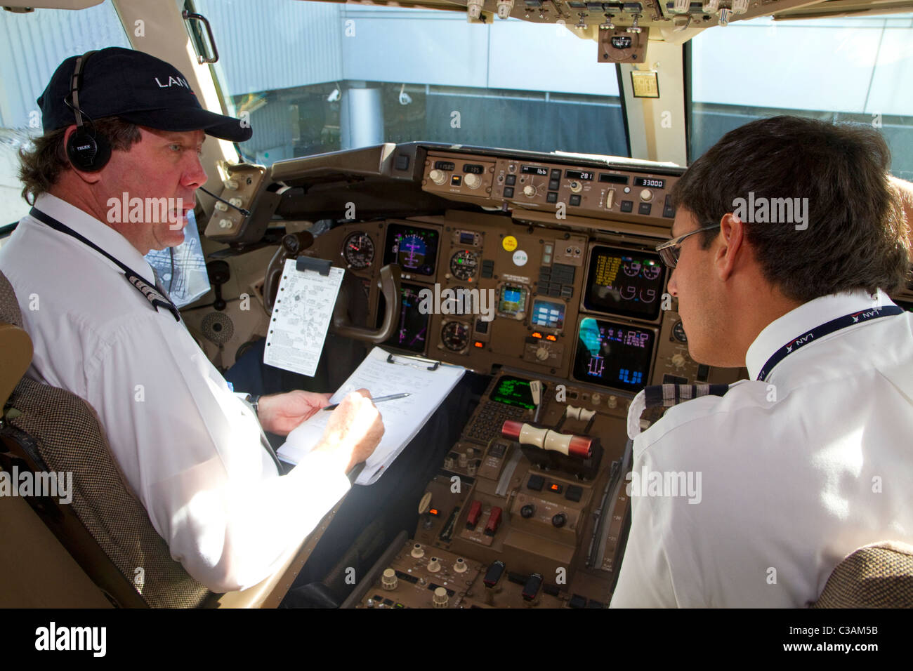Pilote et copilote d'examiner une liste de pré-vol dans le cockpit d'un Boeing 767. Banque D'Images