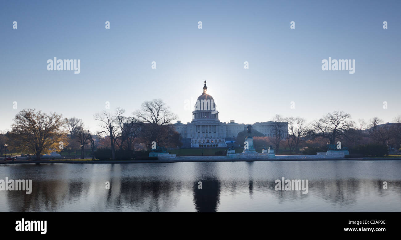 Aube du ciel lumineux derrière le dôme lumineux du Capitole à Washington DC avec la piscine et ses statues Banque D'Images