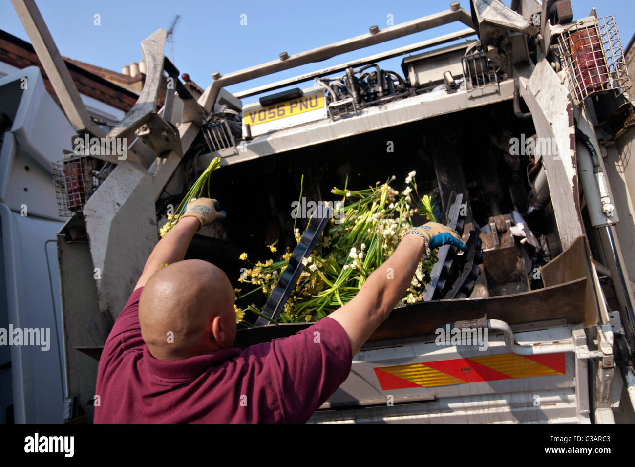 L'homme de jeter des fleurs dans un camion poubelle Londres à Columbia Road Flower Market Banque D'Images