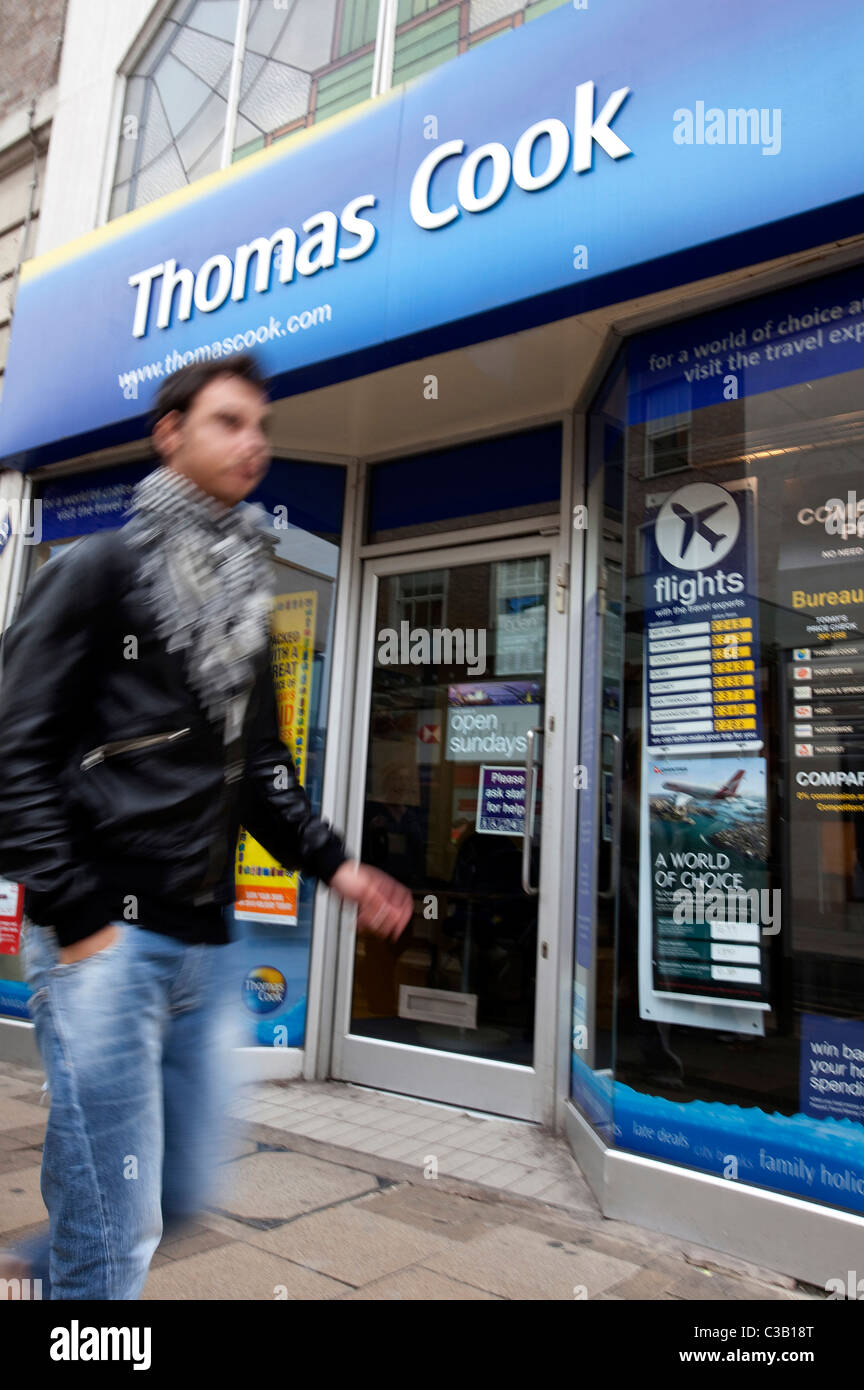 Une personne passe devant une agence de voyage, Cambridge. Banque D'Images