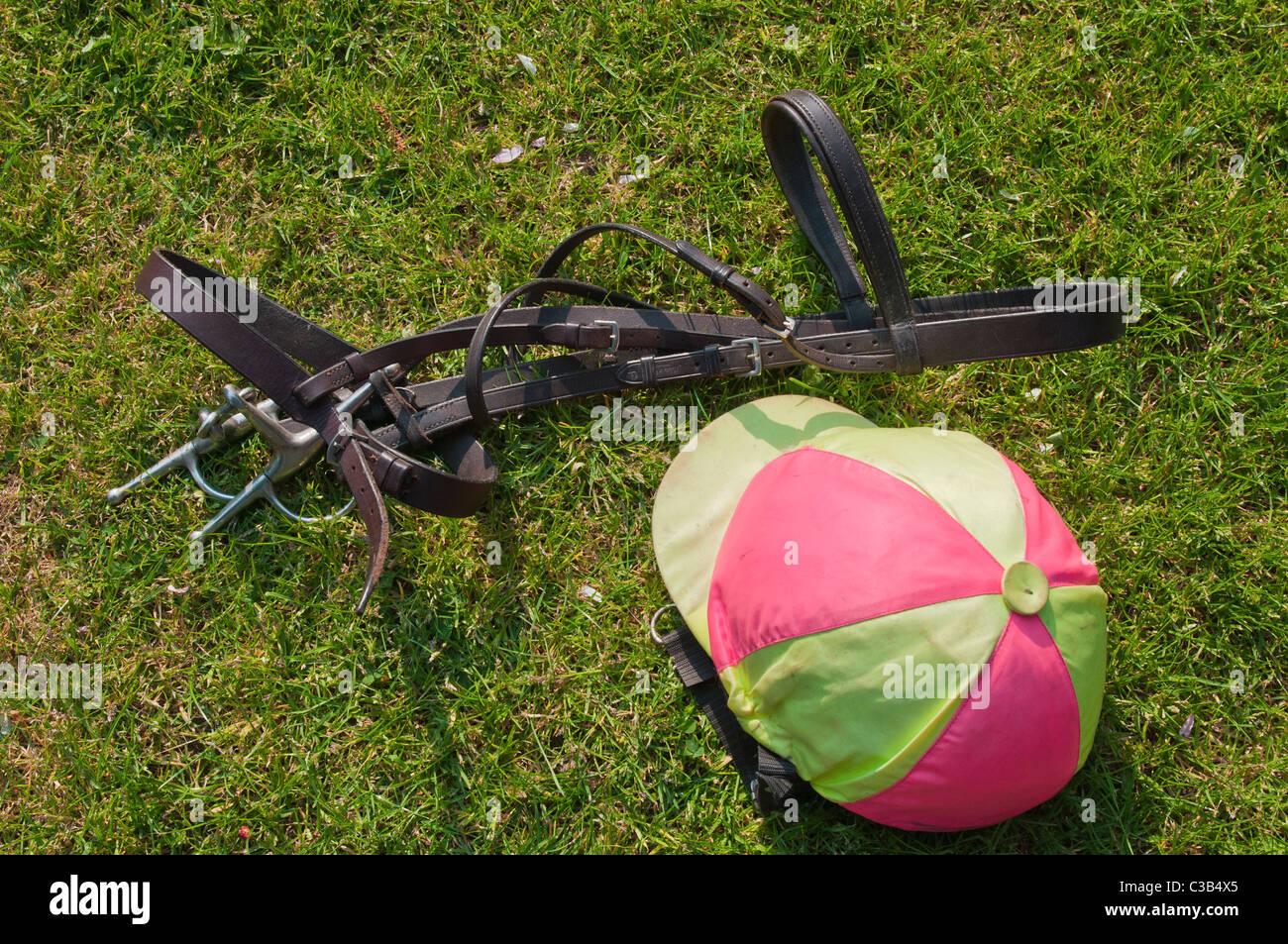 Jockey chapeau de crâne et la patte sur l'herbe Equestrian Banque D'Images