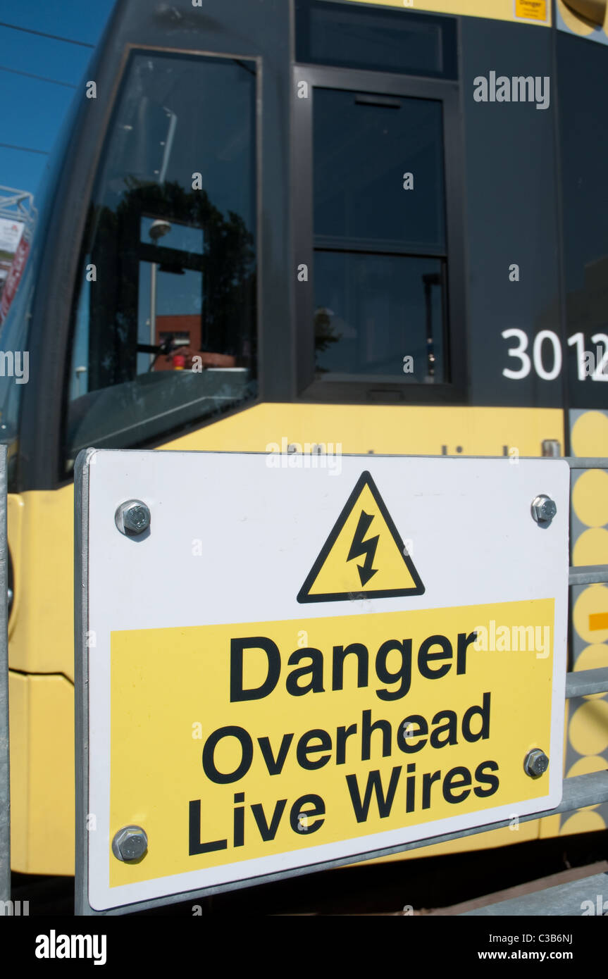 Les frais généraux de danger Live Wires panneau d'avertissement avec Mertolink tram passant. Banque D'Images