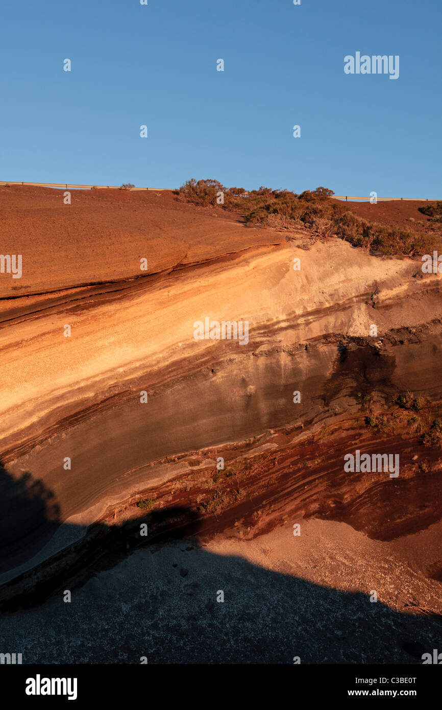 Des couches de roches baignées de soleil de fin de soirée montrent les différentes couleurs des débris volcaniques déposées le long millenia Tenerife Banque D'Images