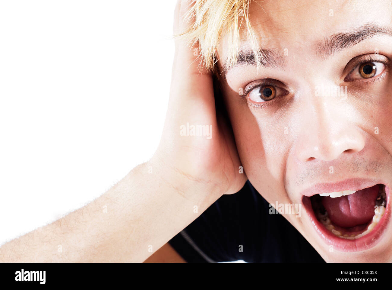 Face close up of young man screaming avec sa main sur le visage Banque D'Images
