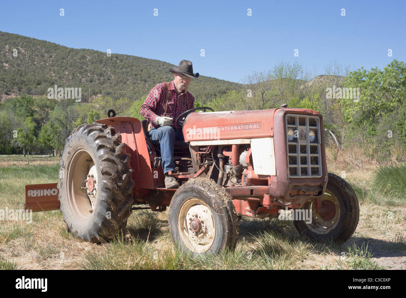 Agriculteur et éleveur américain prépare le sol pour les semis de printemps, dans la vallée de Hondo, Nouveau Mexique. Banque D'Images