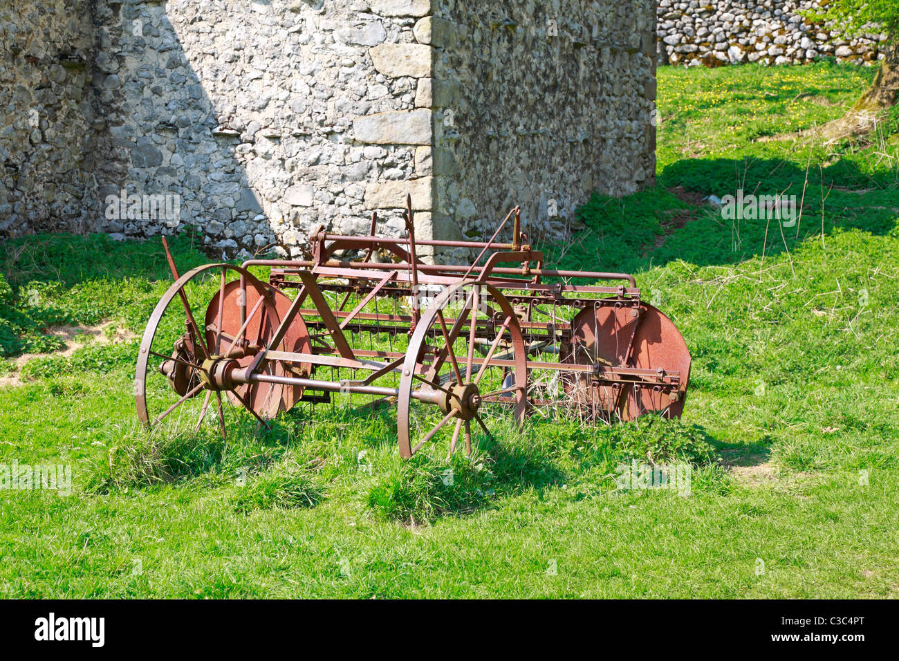 Ancien fer à repasser machines agricoles par une grange à Malham, Yorkshire du Nord, Yorkshire Dales National Park, England, UK. Banque D'Images