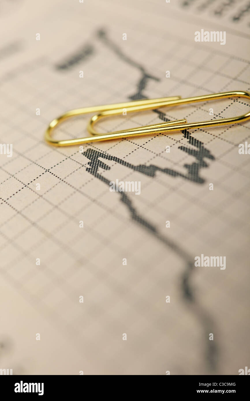 De plus en plus marché macro stock graphique de tendance dans la presse financière et d'un trombone d'or ci-dessus. Banque D'Images