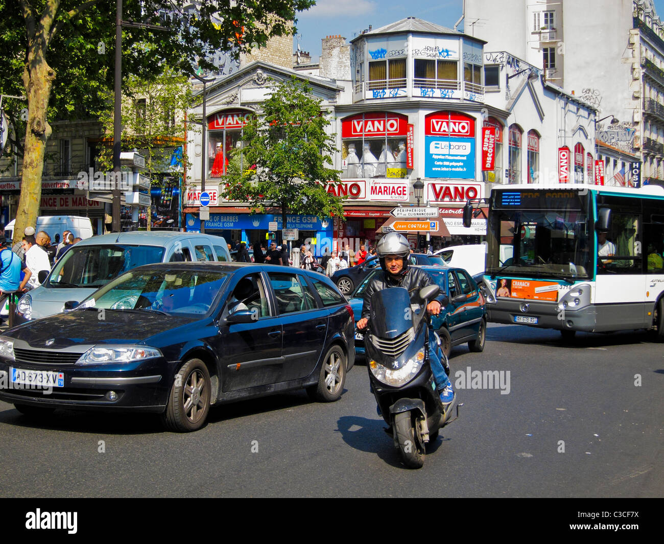 Paris France voitures scenes de rue animees quartier barbes avec vieux magasin de mariage Vano en arriere plan detruit dans le feu paris homme conduisant la rue de moto Paris dans la journee